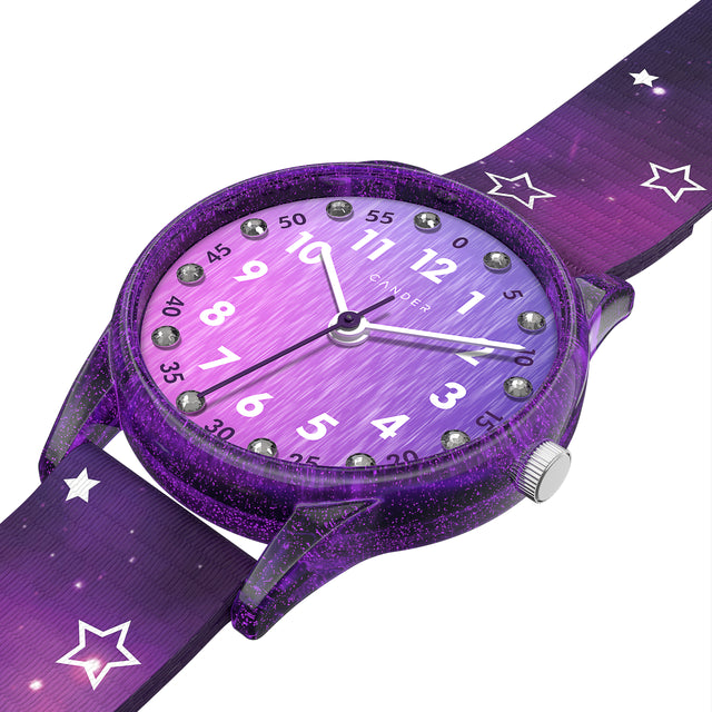 Eine Kinder-Armbanduhr mit einem lila Stoffarmband, auf dem kleine Sterne abgebildet sind. Das lila-transparente Gehäuse hat ein Glitzereffekt. Auf dem Ziffernblatt befinden sich kleine Schmucksteine. Die weißen Zahlen auf dem lila Ziffernblatt sind sehr gut ablesbar.
