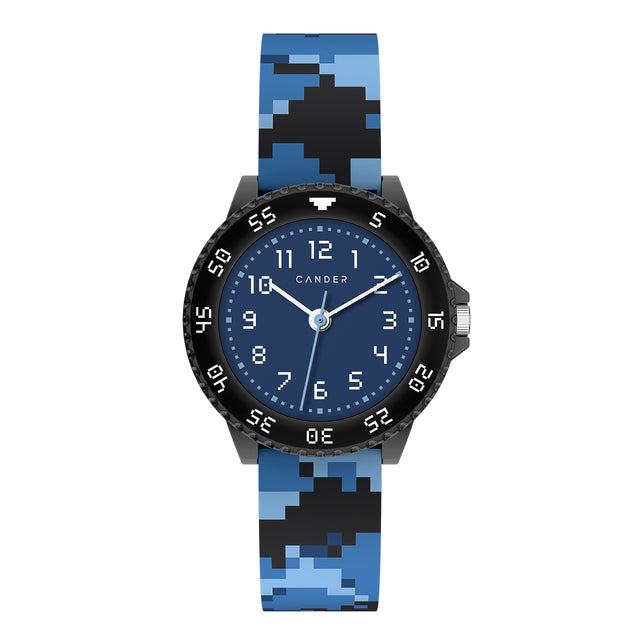 Eine Kinder-Armbanduhr in Pixel-Look. Auf dem Armband sind blaue und schwarze Pixel zufällig angeordnet. Die weißen Ziffern auf dem schwarzem Gehäuse und dem blauen Ziffernblatt sind ebenfalls im Pixel-Look. Die Uhr verfügt über eine verstellbare Lynette in schwarz. 