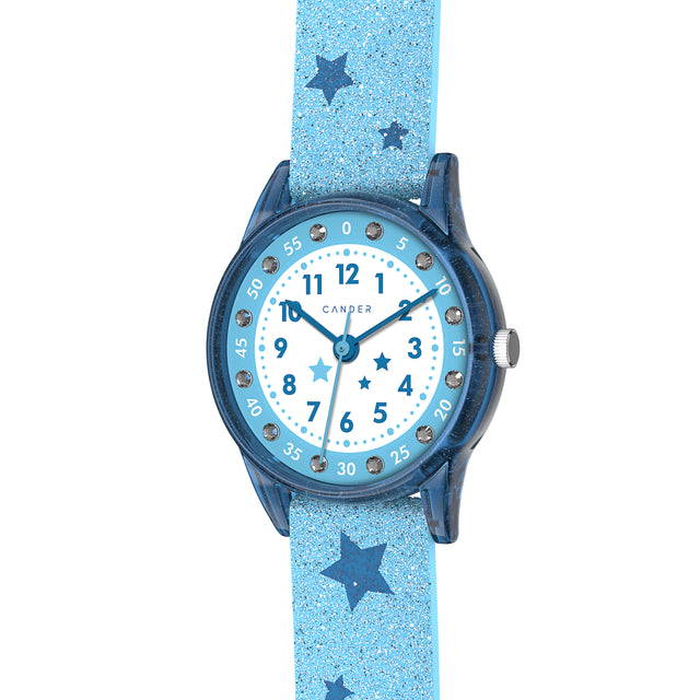 Eine Kinder-Armbanduhr mit einem hellblauen Glitzerarmband, auf dem dunkelblaue Sternchen abgebildet sind, blau-transparentem Gehäuse mit eingearbeitetem Glitzer und kleinen Schmucksteinen auf dem Ziffernblatt. Die Zahlen auf dem blau- weißem Ziffernblatt sind sehr gut ablesbar.