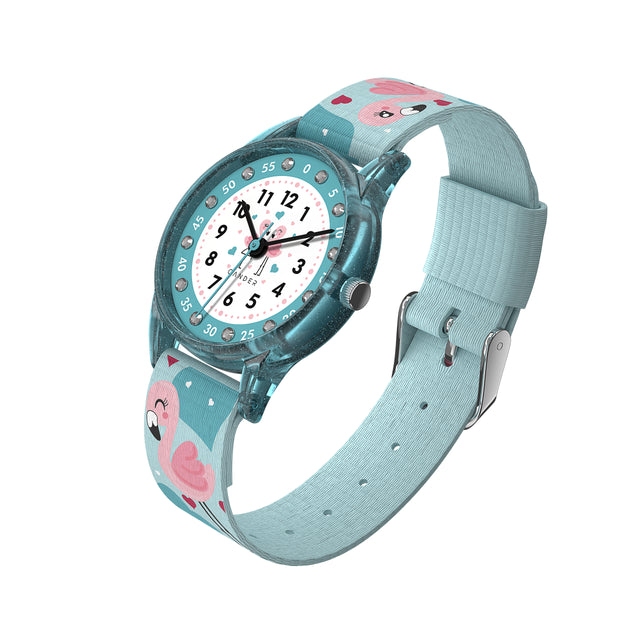 Eine Kinder-Armbanduhr mit einem türkisem Stoffarmband, auf dem super süße Flamingos abgebildet sind. Das türkis-transparentem Gehäuse hat ein Glitzereffekt. Auf dem Ziffernblatt befinden sich kleine Schmucksteine. Die Zahlen auf dem türkis- weißem Ziffernblatt sind sehr gut ablesbar.